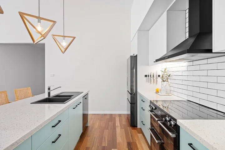 Moderne keuken met zachtgroene fronten en witte tegelwand