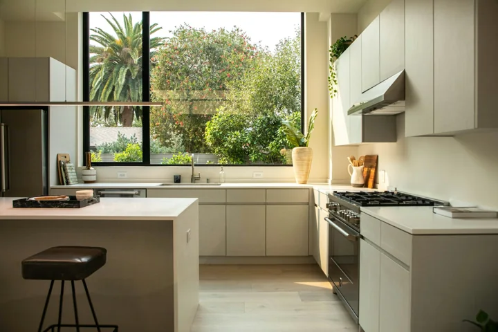 Lichte minimalistische keuken met kookeiland en grote ramen